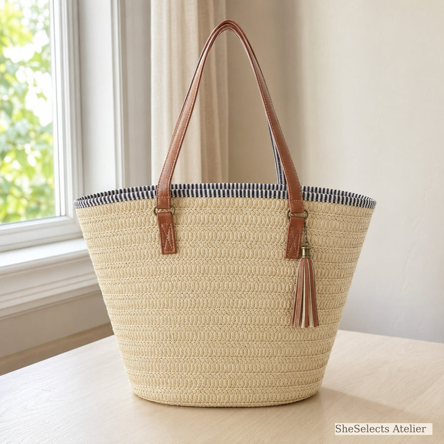 Beige large woven straw tote bag with brown shoulder straps and tassel