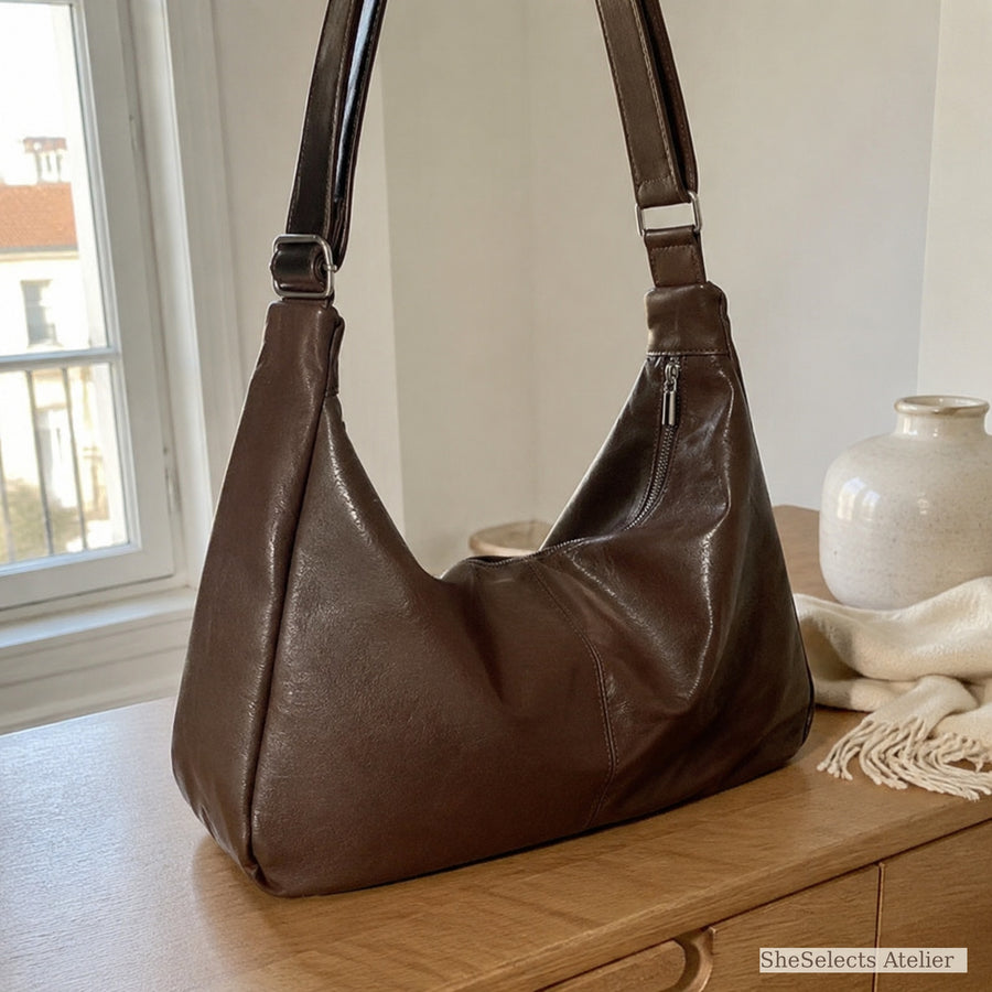 Brown vintage slouchy hobo shoulder bag on a warm oak console