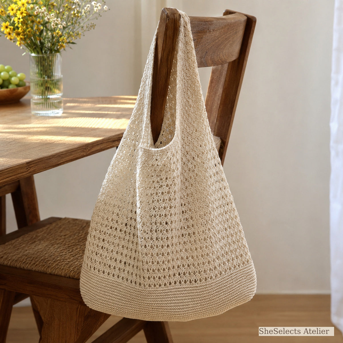 Beige crochet style market bag hanging from a wooden chair