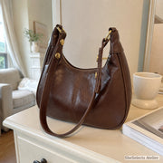 Brown retro vegan leather crescent hobo bag with gold studs and two straps