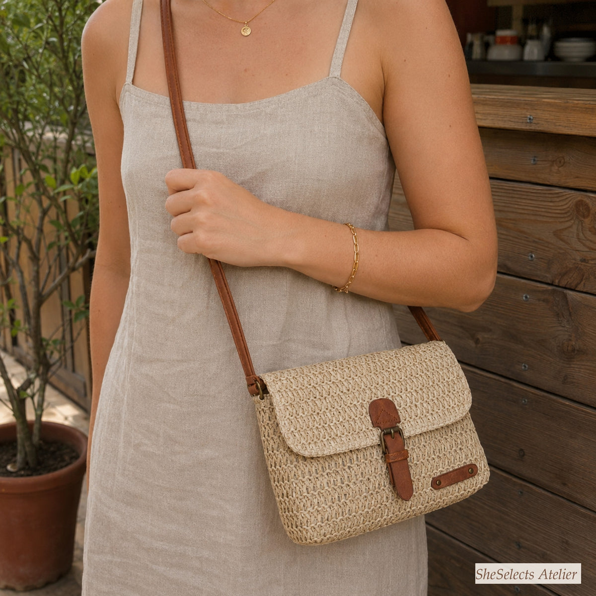 Beige straw crossbody purse worn with a neutral linen summer dress