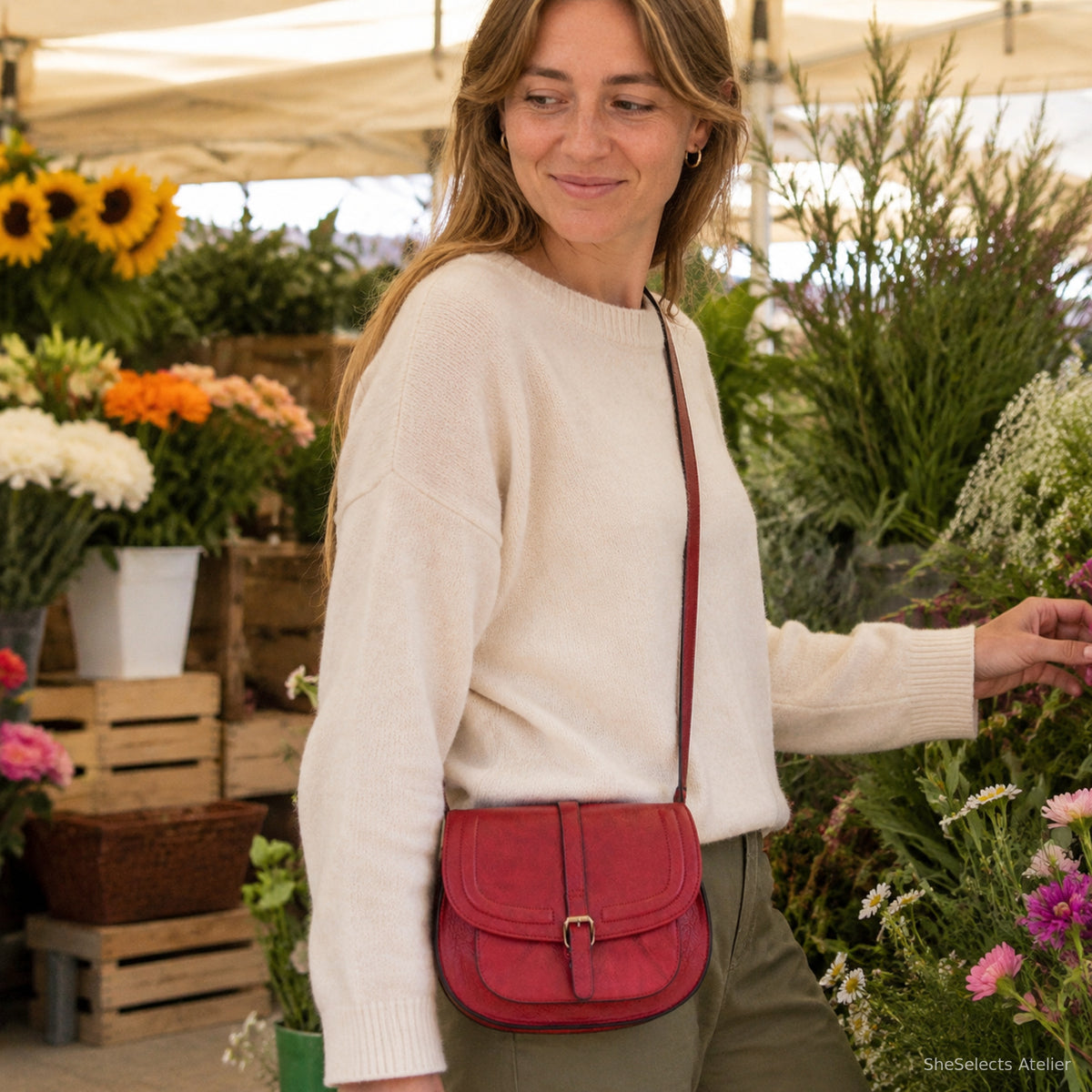 Freckled woman carrying a muted red vintage crossbody bag at a flower market