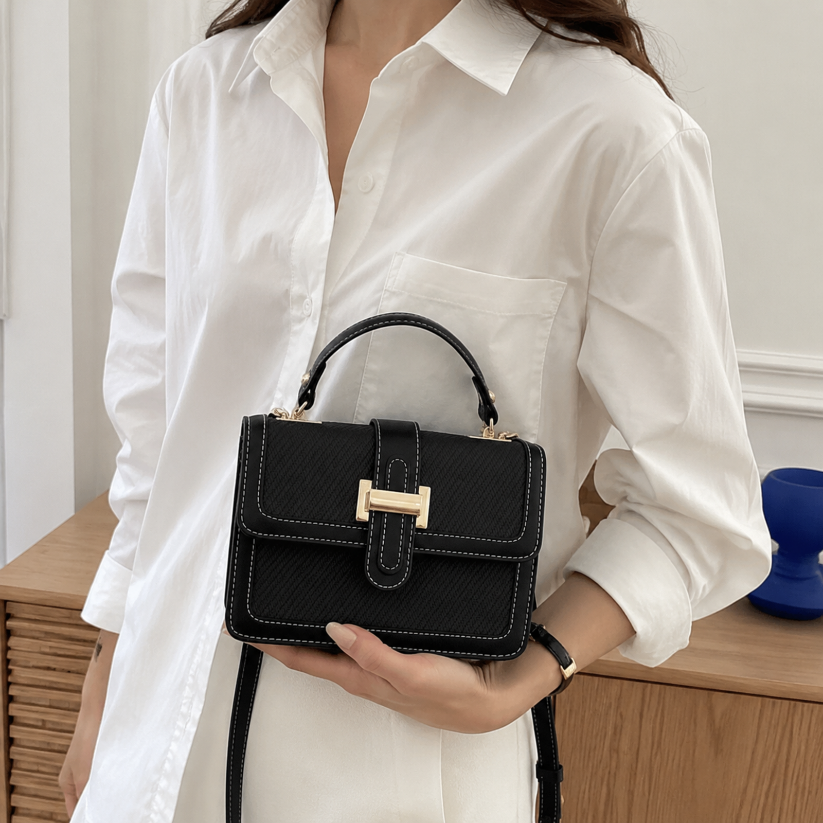 Black textured petite tote held in a cropped lifestyle view