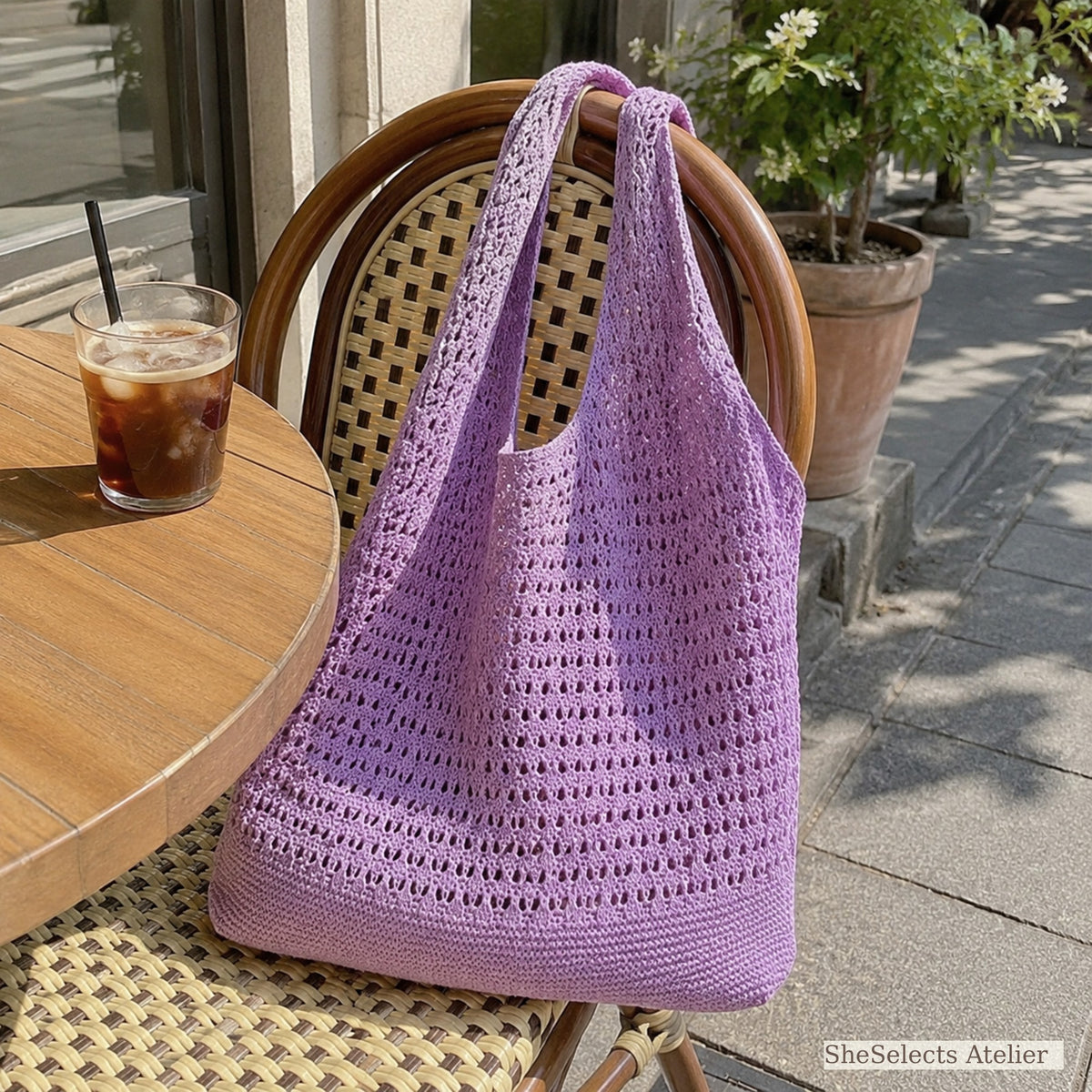 Purple crochet style market bag on an outdoor cafe chair
