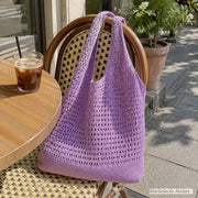 Purple crochet style market bag on an outdoor cafe chair