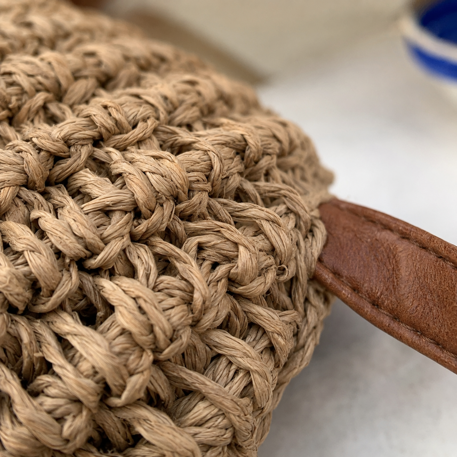 Close-up of chunky straw weave and vegan leather strap attachment