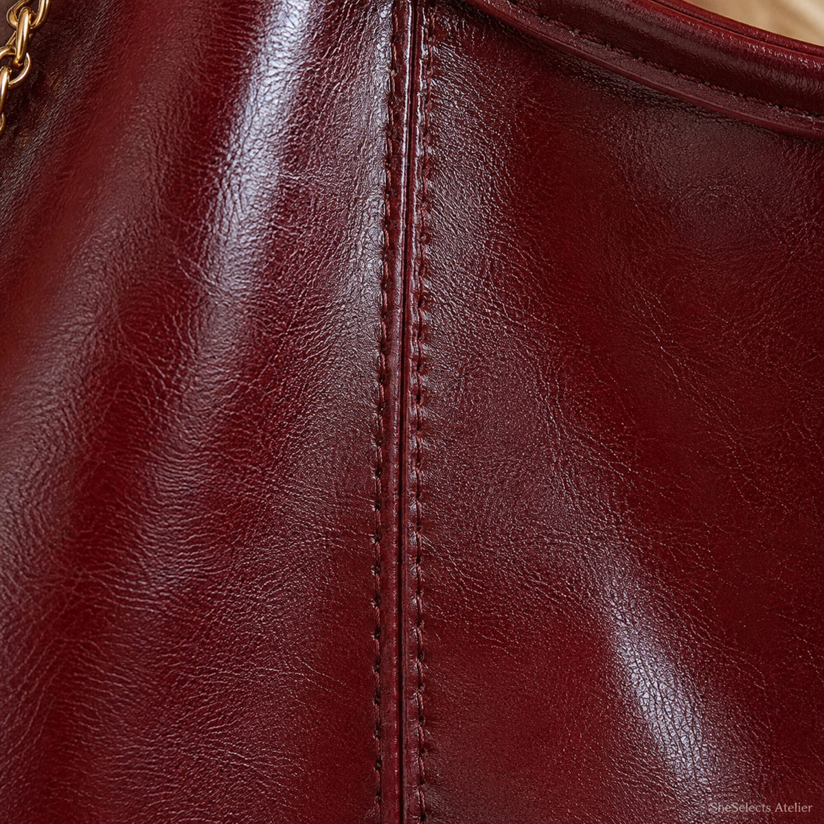 Close-up of Wine Red oil wax effect vegan leather texture and center seam