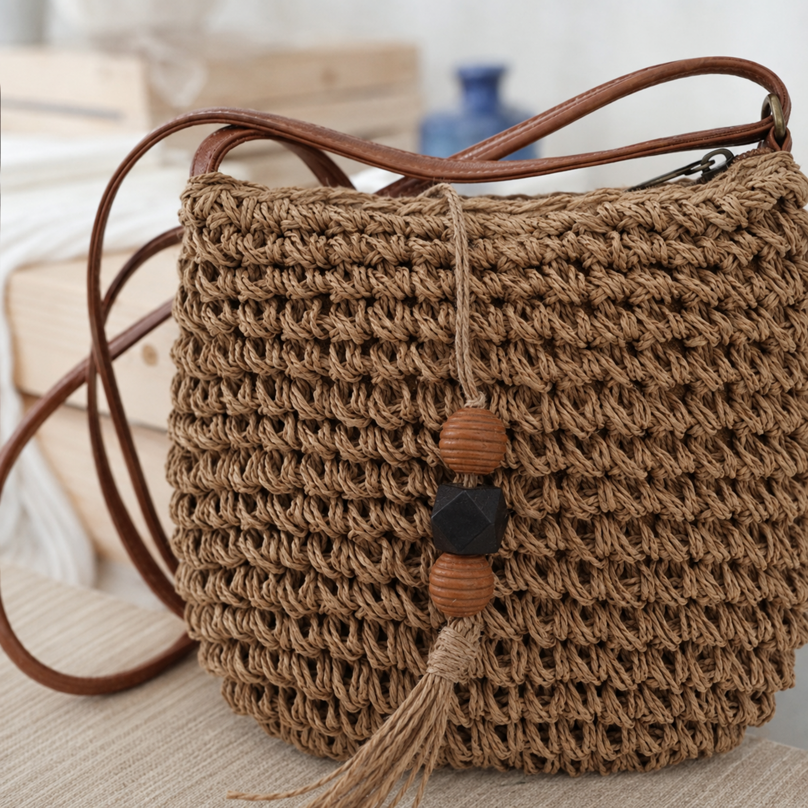 Brown woven crossbody bag with beaded tassel front detail