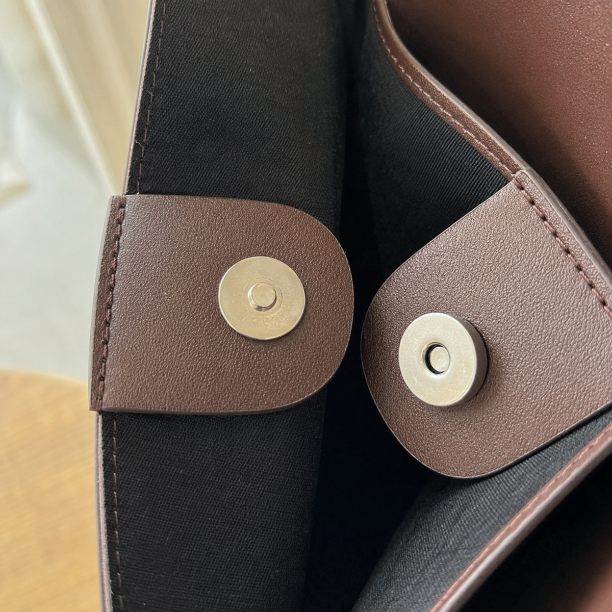 Close-up of the magnetic snap and reinforced vegan leather trim