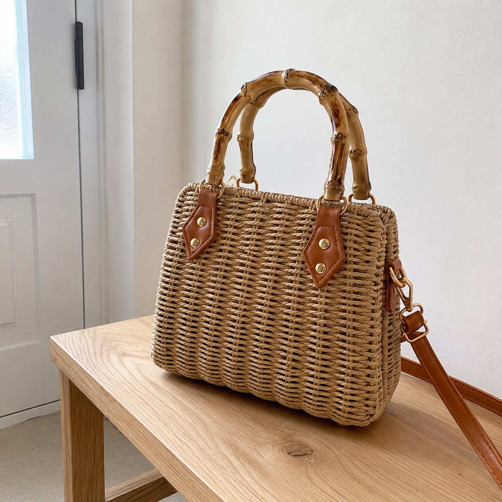 Back and side view of the structured straw handbag with bamboo handles and shoulder strap