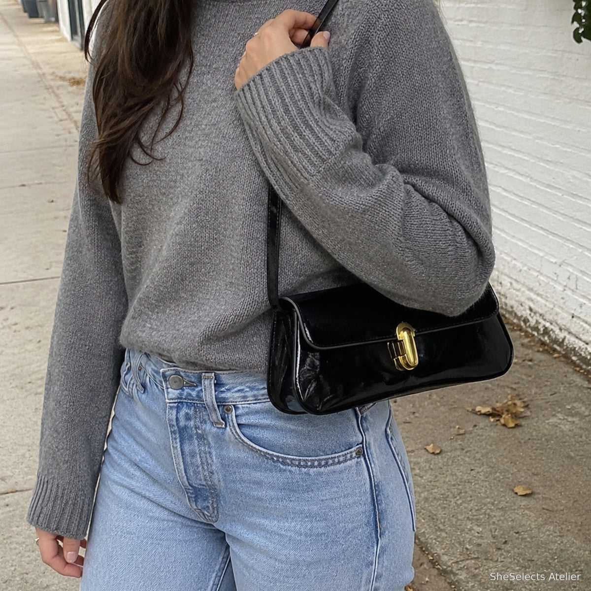 Black glossy vegan leather underarm bag in a casual outdoor style photo