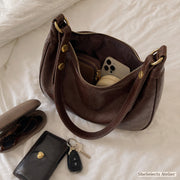 Brown crescent hobo purse open with everyday essentials inside