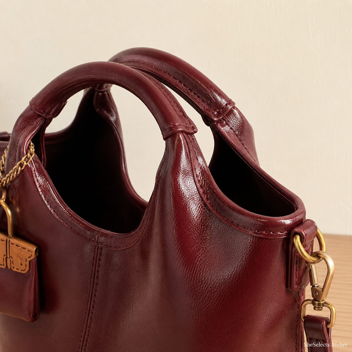 Close-up of padded circular handles and antique gold shoulder strap hardware