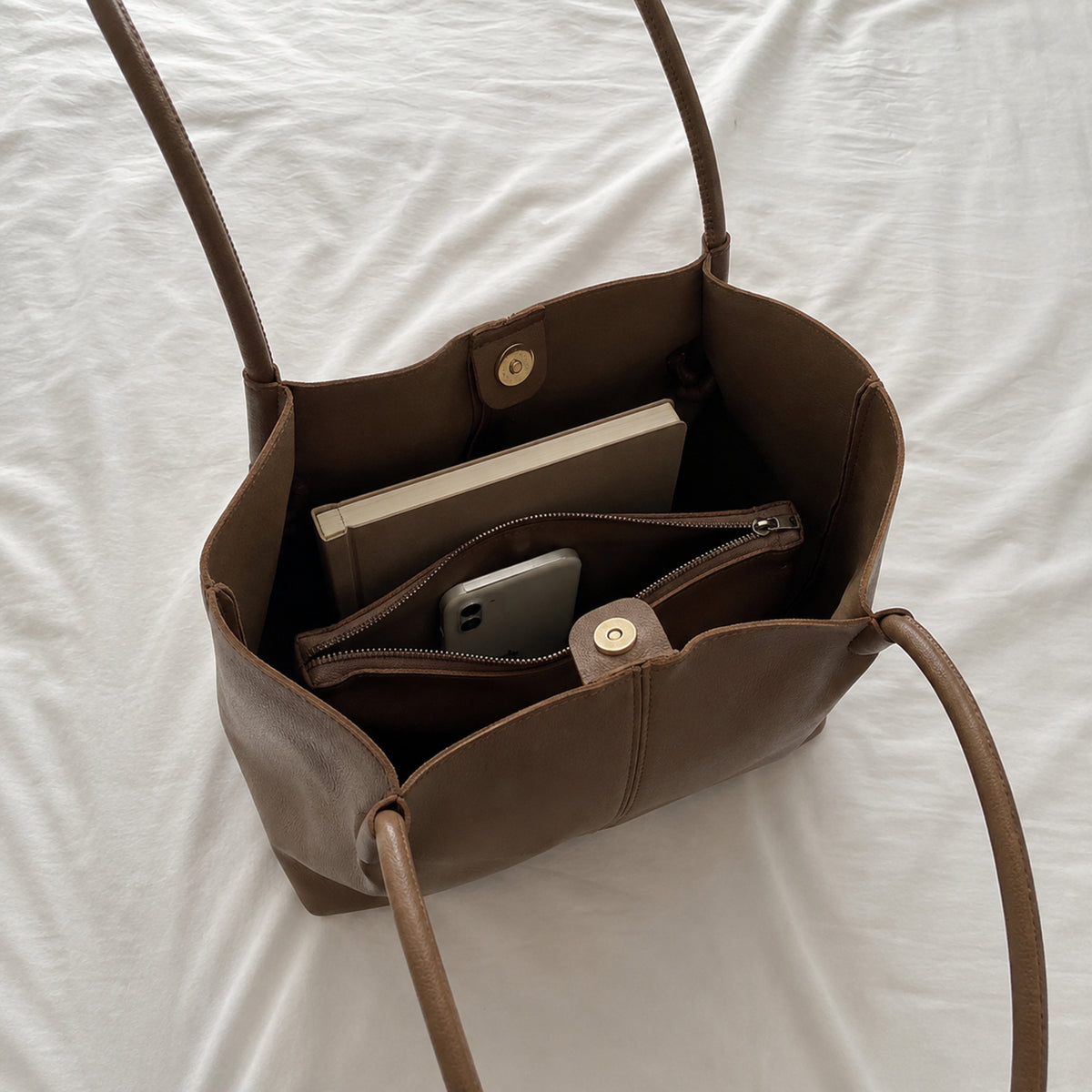 Open coffee brown tote showing magnetic snaps and central zippered divider compartment