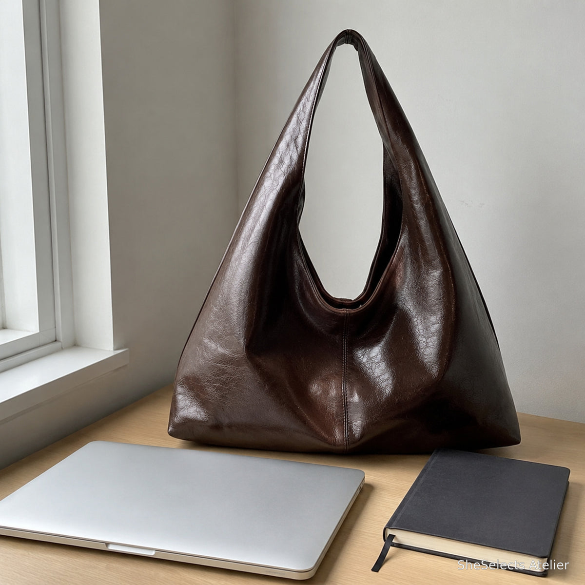 Coffee brown everyday shoulder tote beside a laptop and notebook on a desk