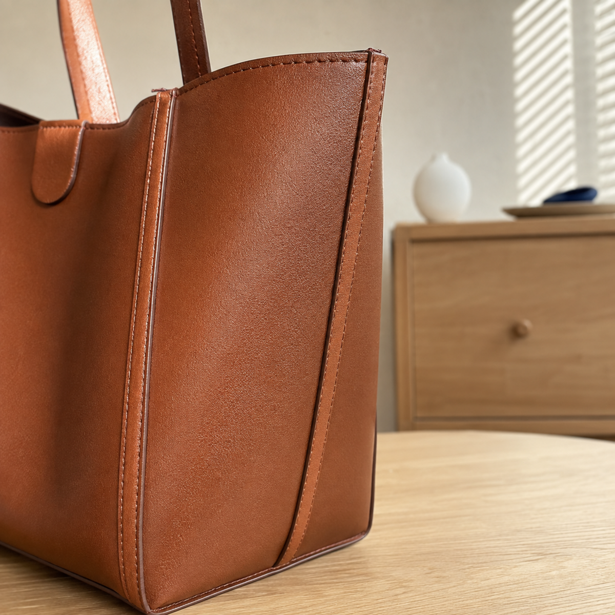Side view showing the tall gusset and structured base of the brown tote