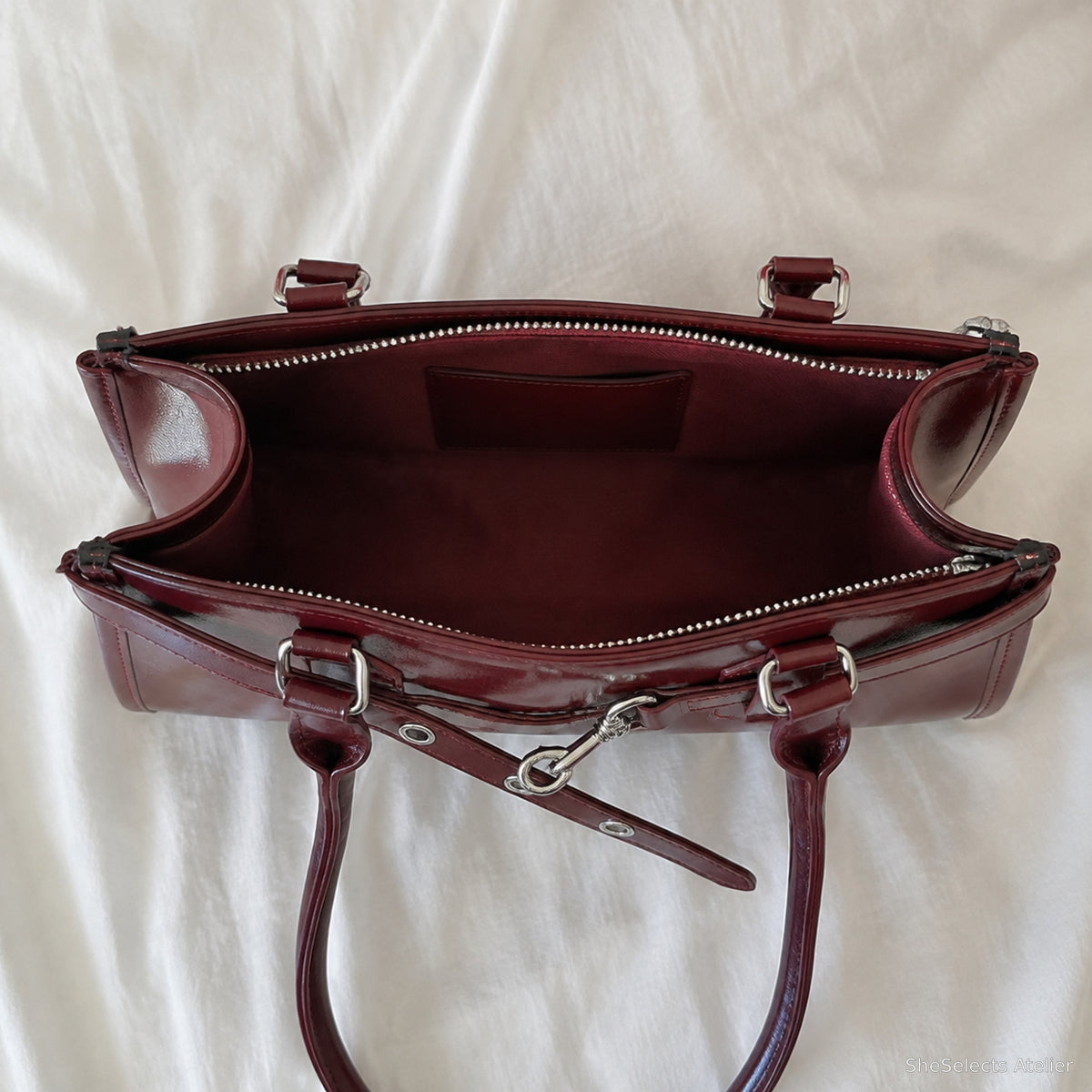 Open burgundy baguette bag showing one main compartment and card slip pocket