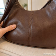 Close view of soft brown vegan leather texture and stitched panel seams