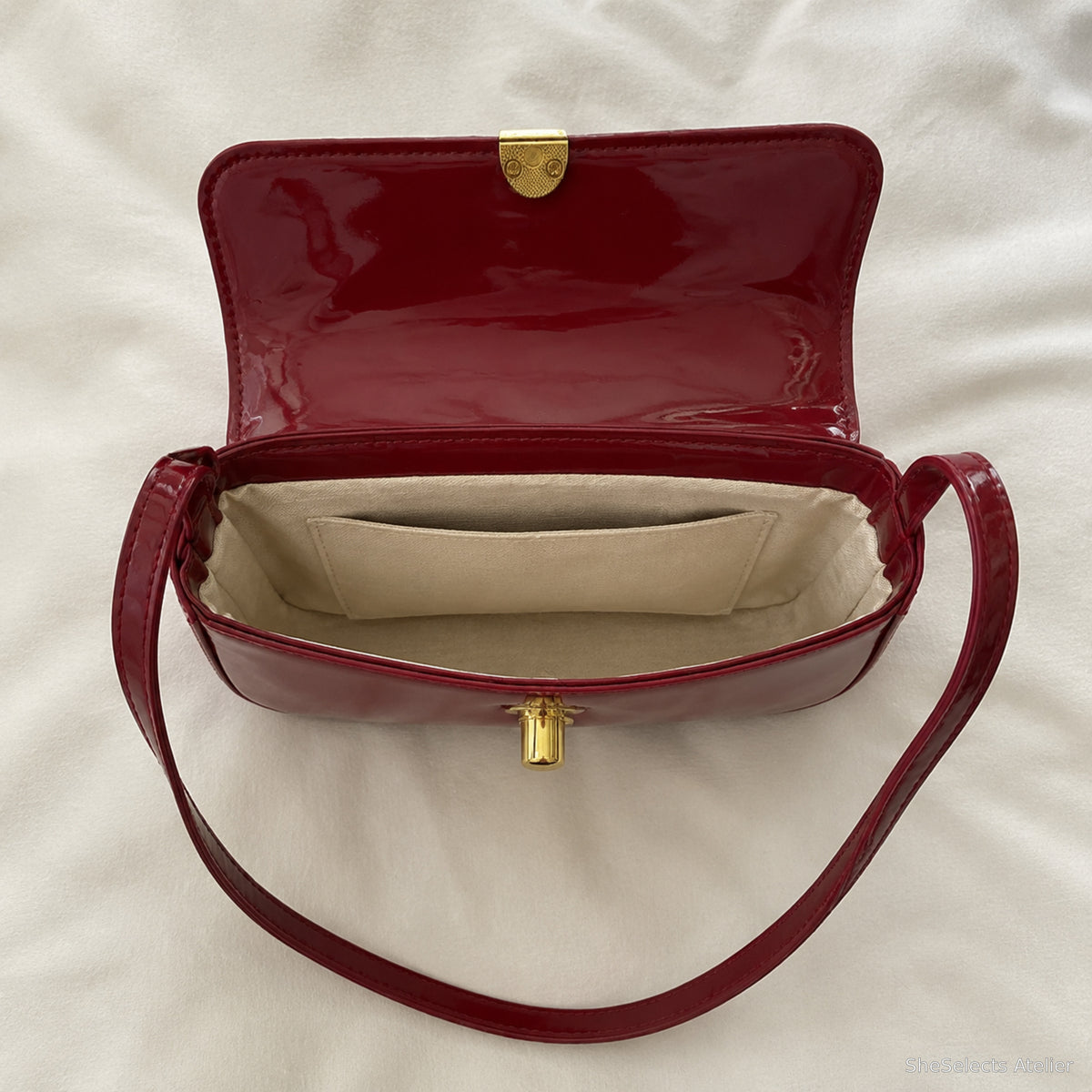 Open Wine Red baguette bag showing beige lining main compartment and patch pocket