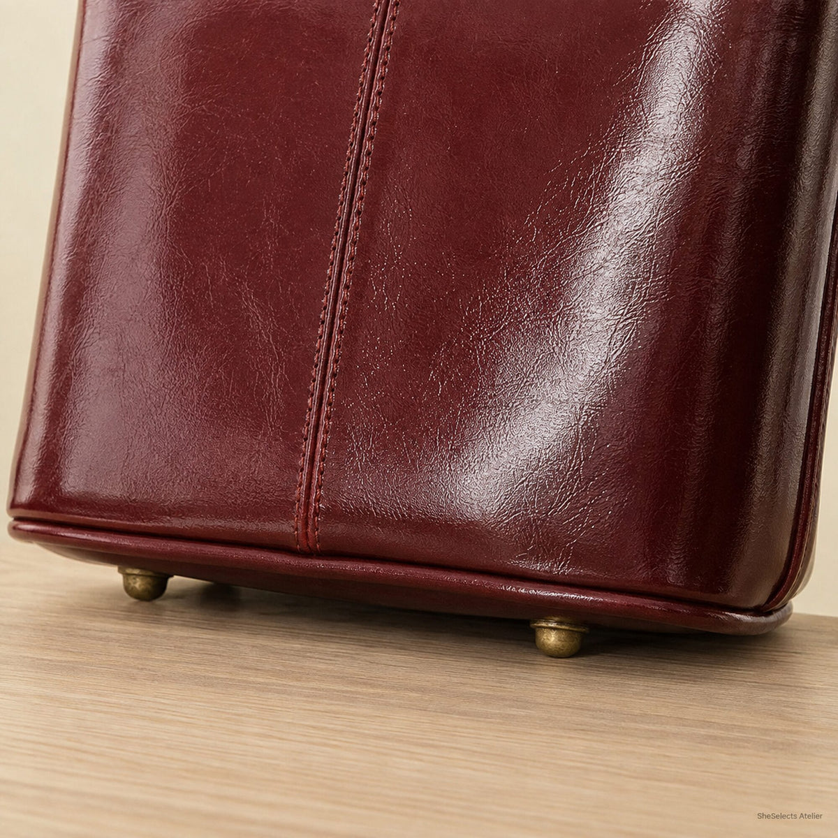 Close-up of protective metal feet on Wine Red vegan leather tote base