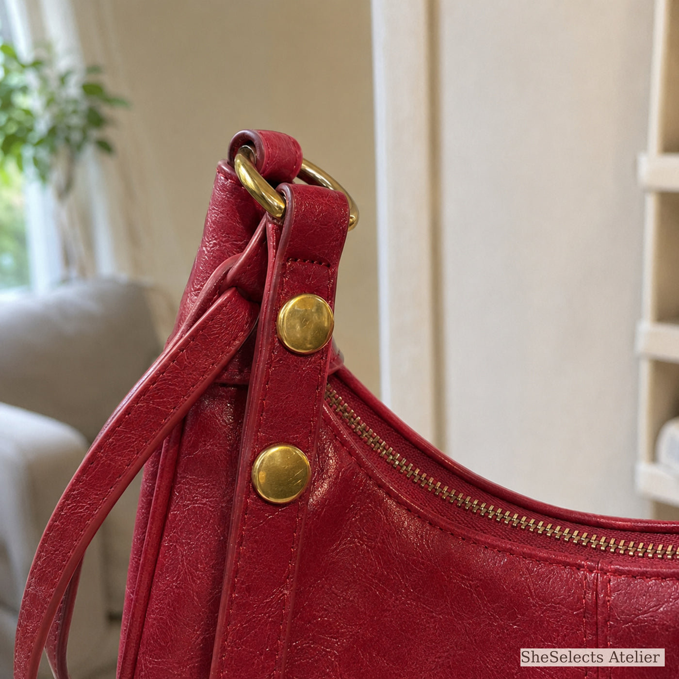 Close view of red shoulder bag gold studs rings and strap attachment