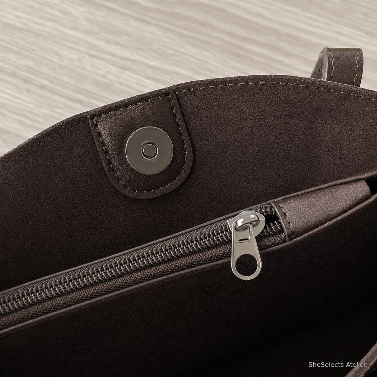Close view of tote magnetic snap and center divider zipper hardware