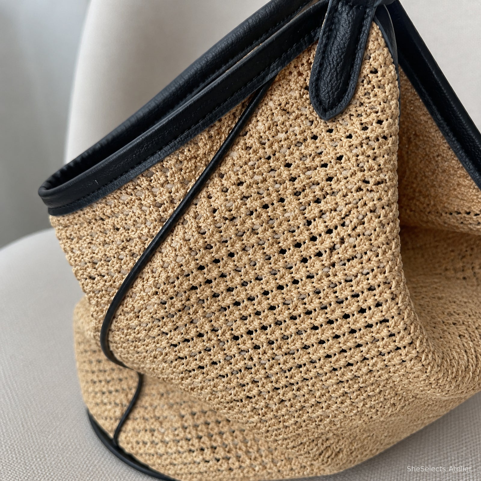 Close-up of natural woven texture, black PU edging, stitching, and base trim