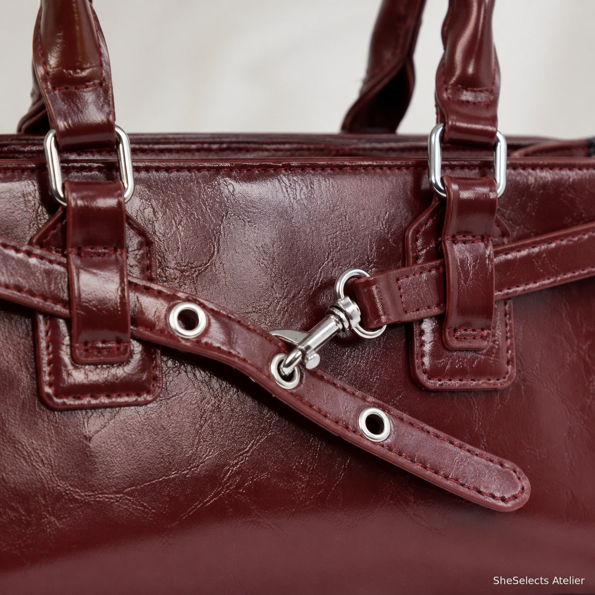 Close-up of silver hook and grommet details on the burgundy bag