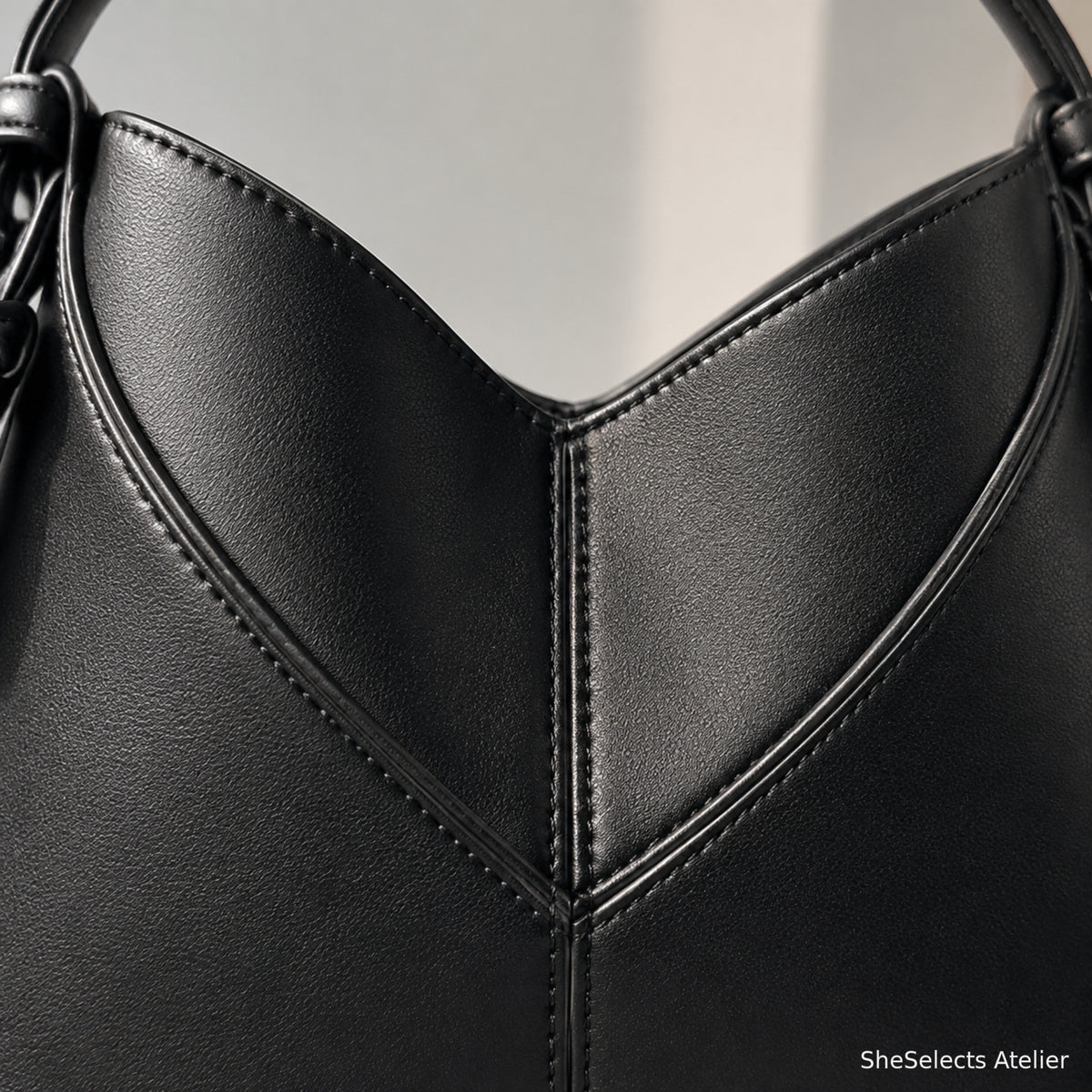Close-up of V-shaped stitching and smooth black vegan leather