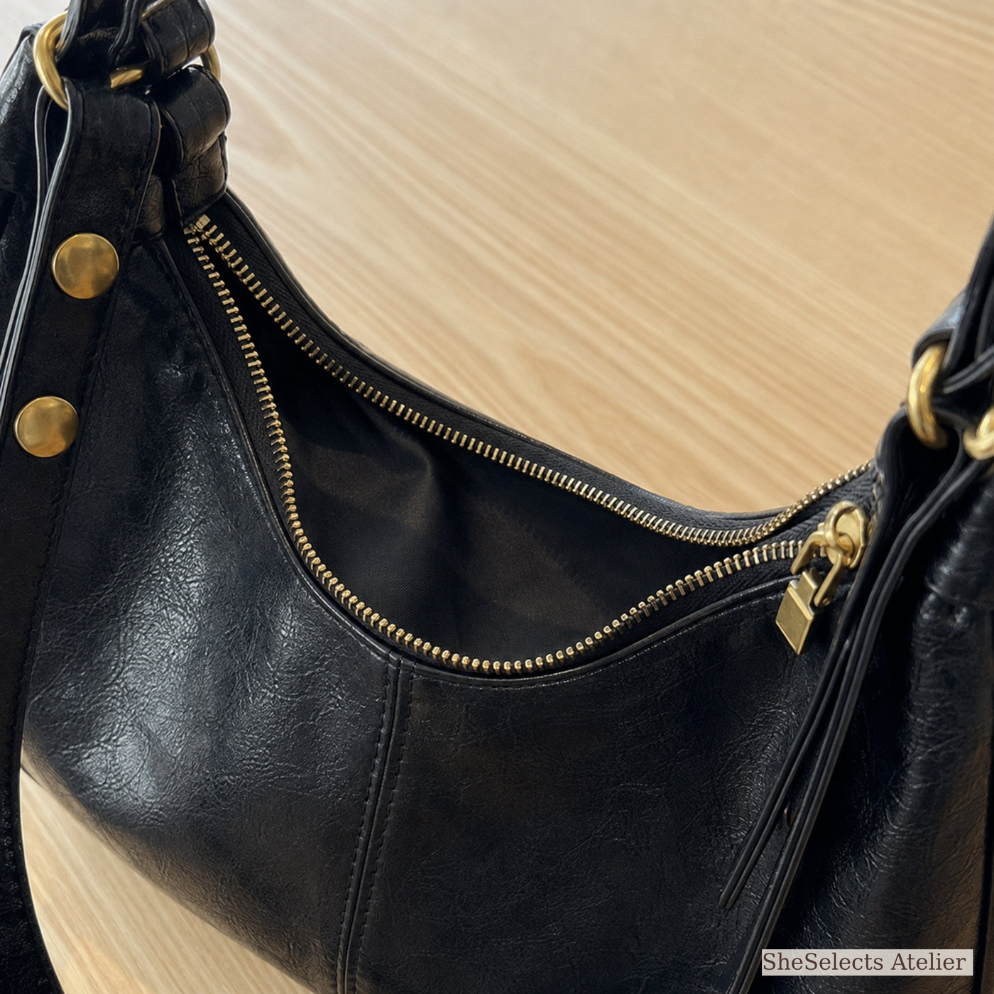 Black vegan leather purse curved gold zipper and dark fabric lining