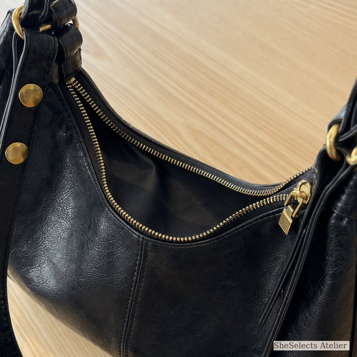 Black vegan leather purse curved gold zipper and dark fabric lining