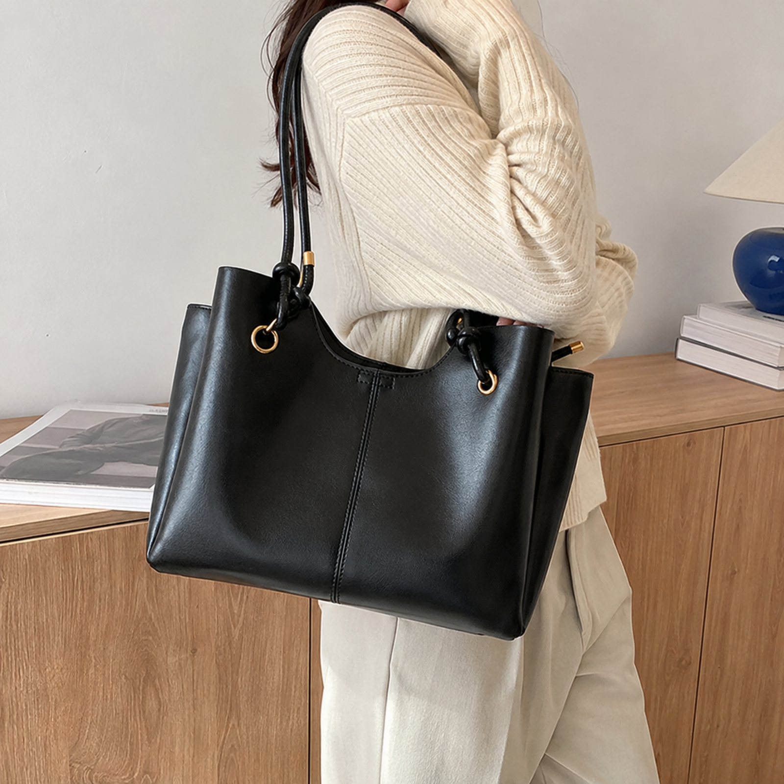 Black compartment tote worn on the shoulder for commuting