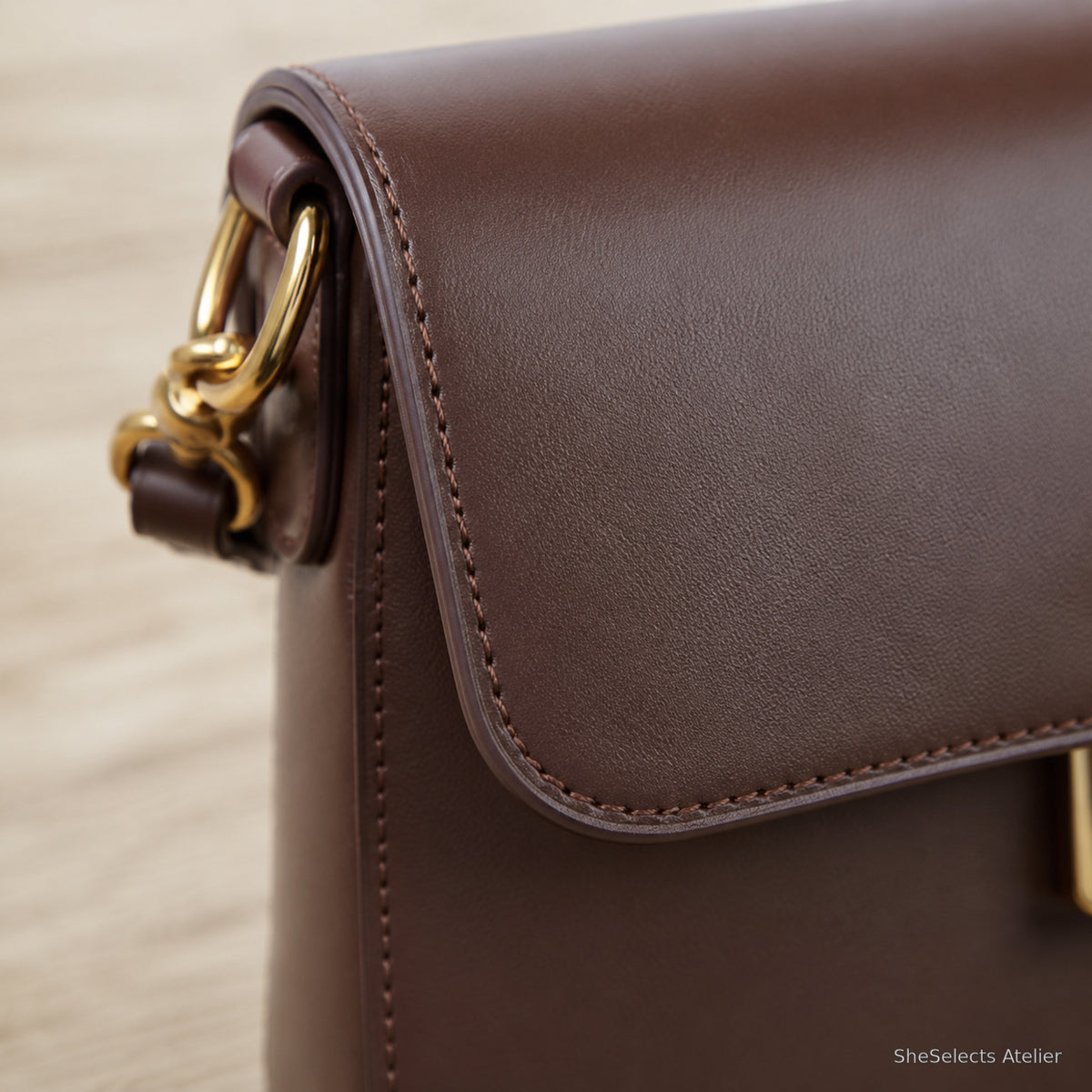 Close view of smooth dark brown cowhide grain and precise stitching