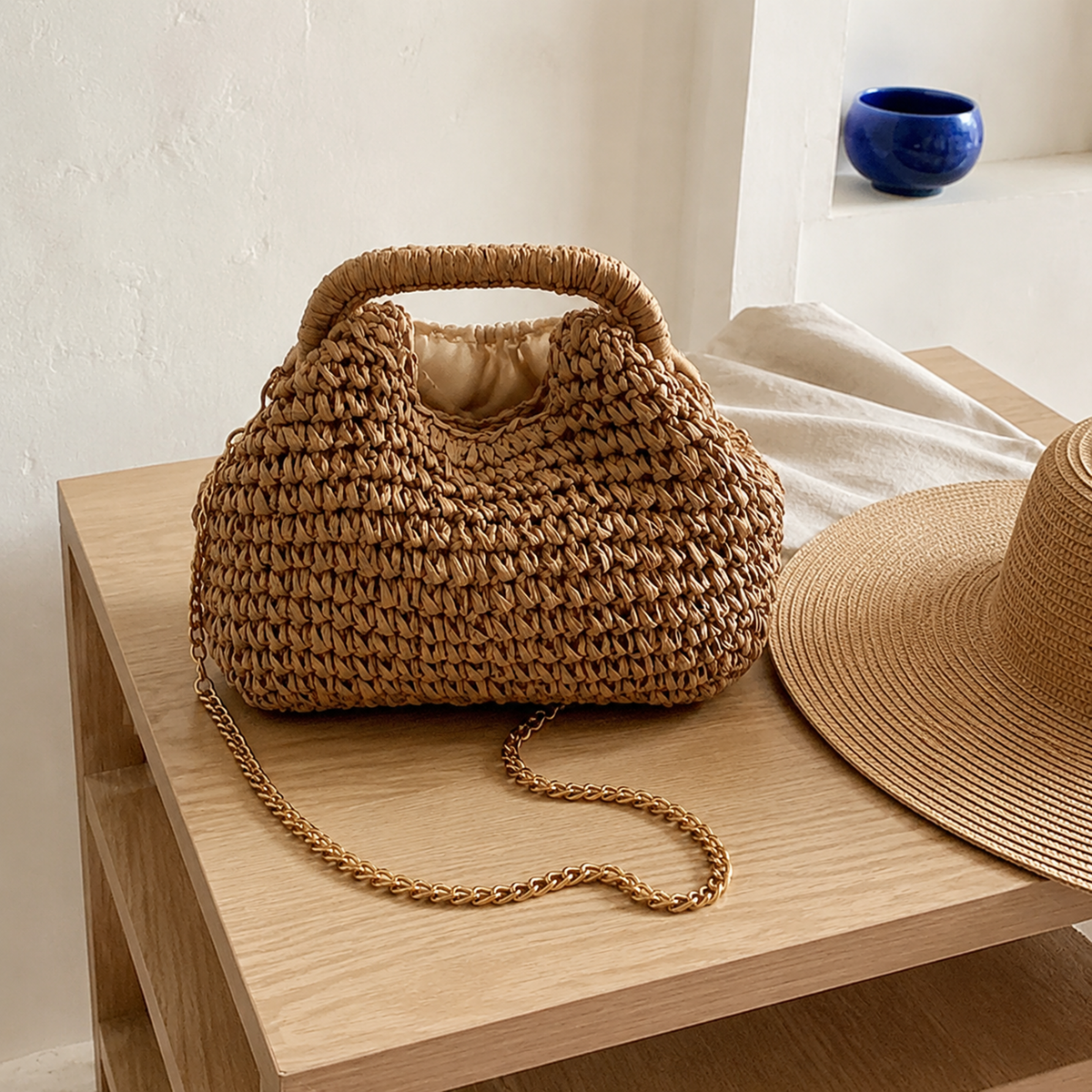 Brown straw crossbody bag with matching sun hat in soft window light