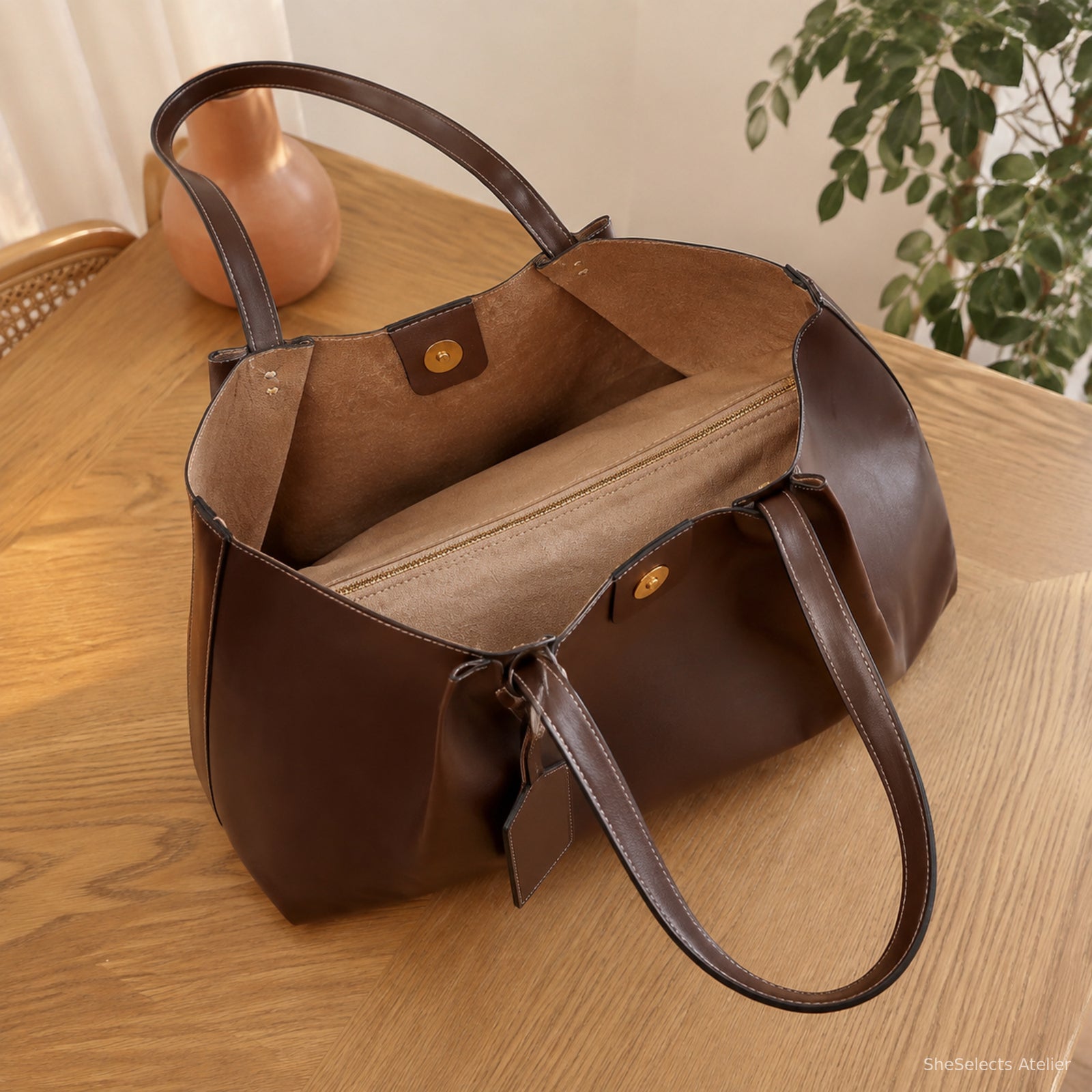 Open dark brown structured tote showing tan lining and central zip divider