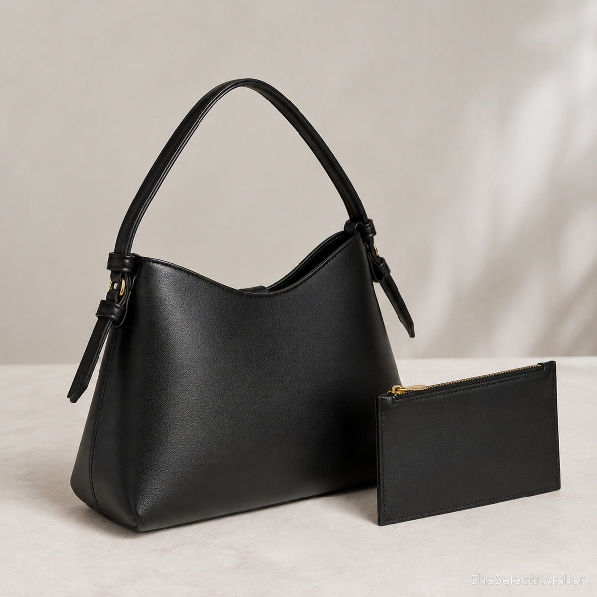 Back and side view of black vegan leather oval hobo bag
