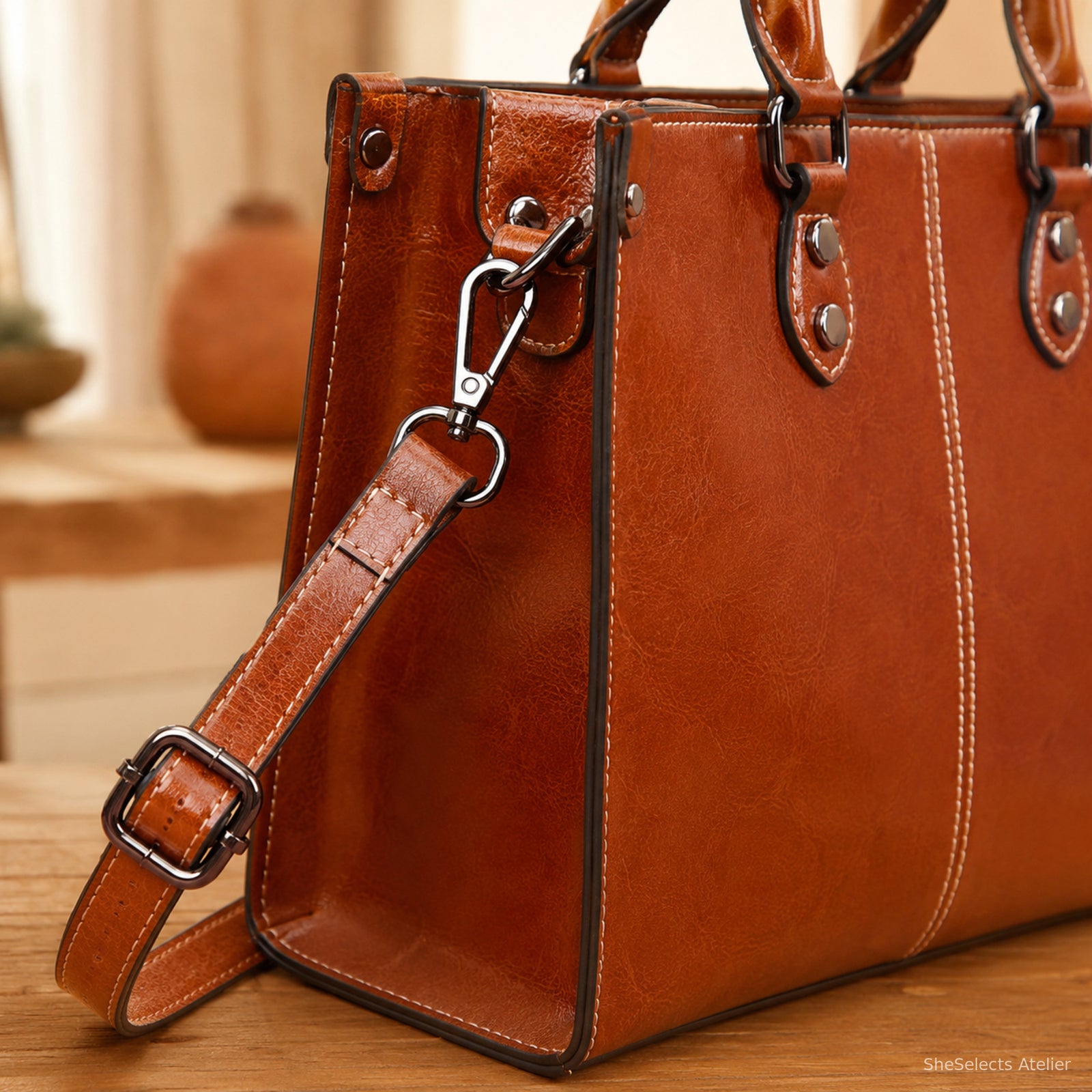 Close-up of cognac cowhide bag detachable strap clip, D-ring, and adjuster