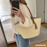 Customer mirror selfie wearing a beige woven straw tote bag