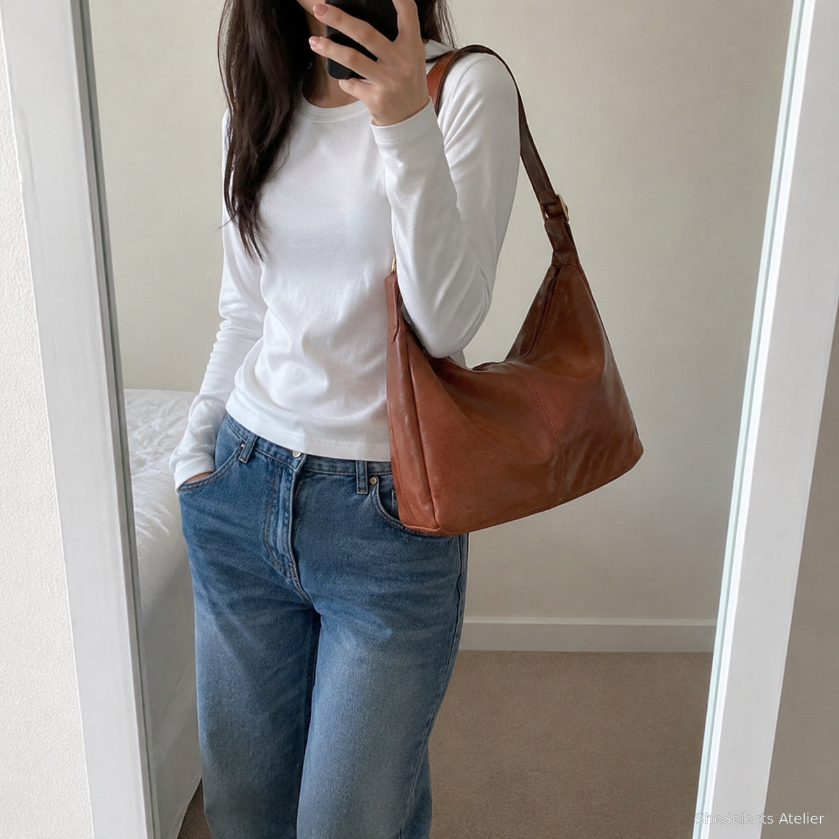 Customer style mirror photo of the light brown hobo bag worn on one shoulder