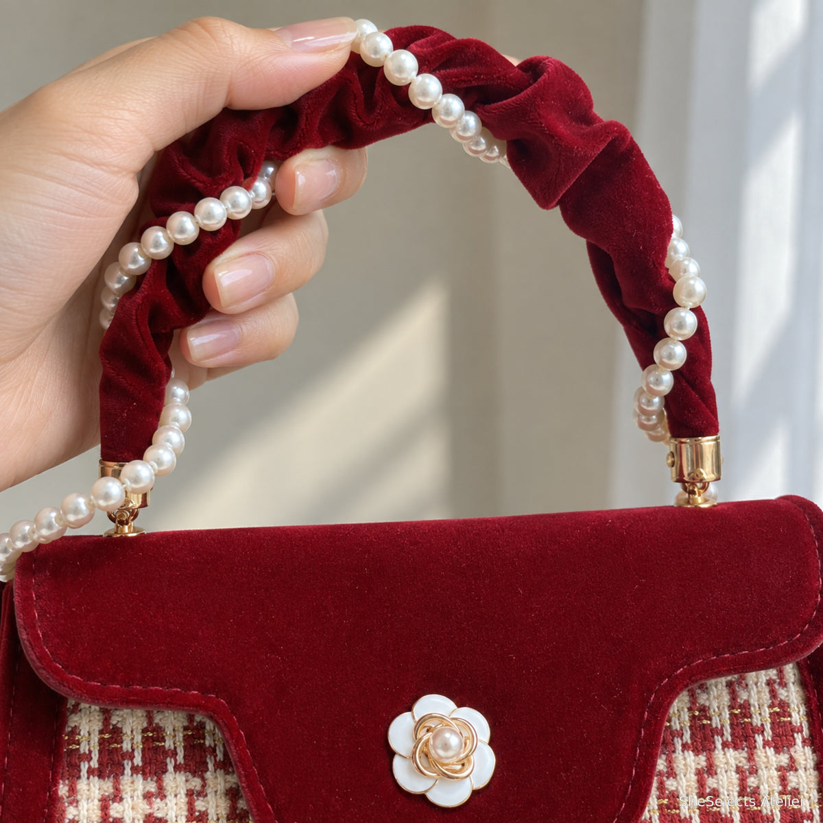 Pearl trimmed ruched wine red velvet handle close up