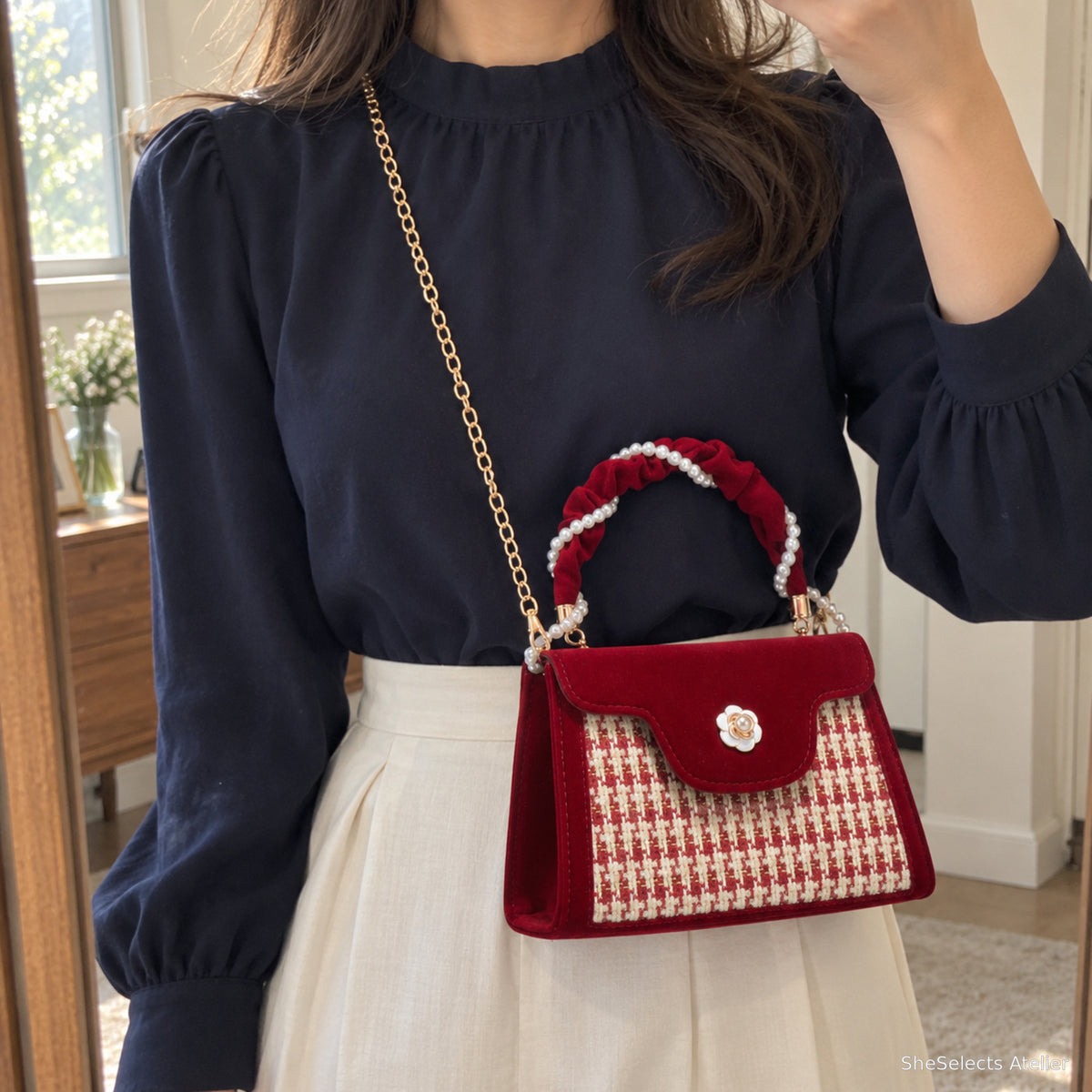 Wine red bag worn crossbody in modest navy blouse