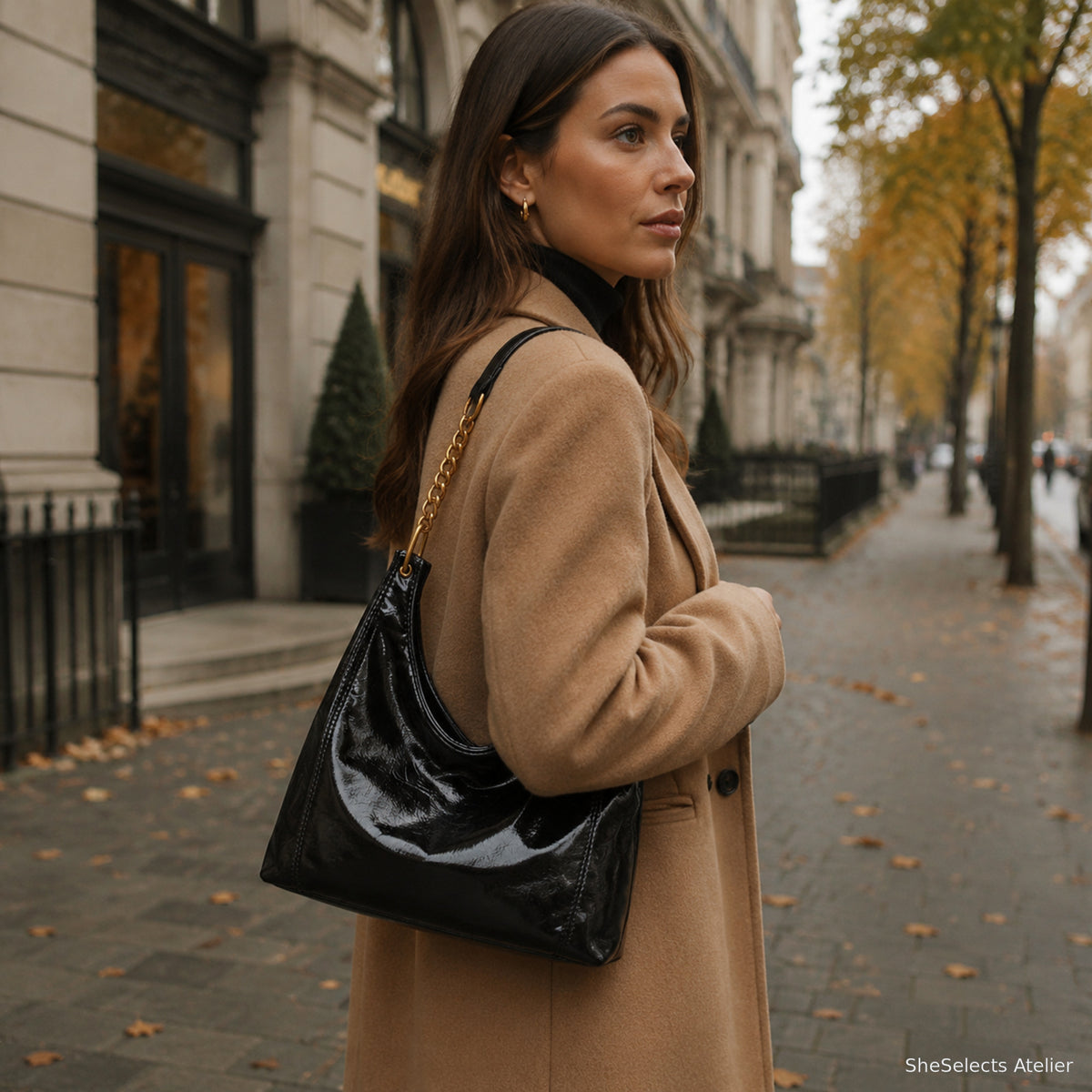 Black glossy hobo shoulder bag styled with an autumn coat