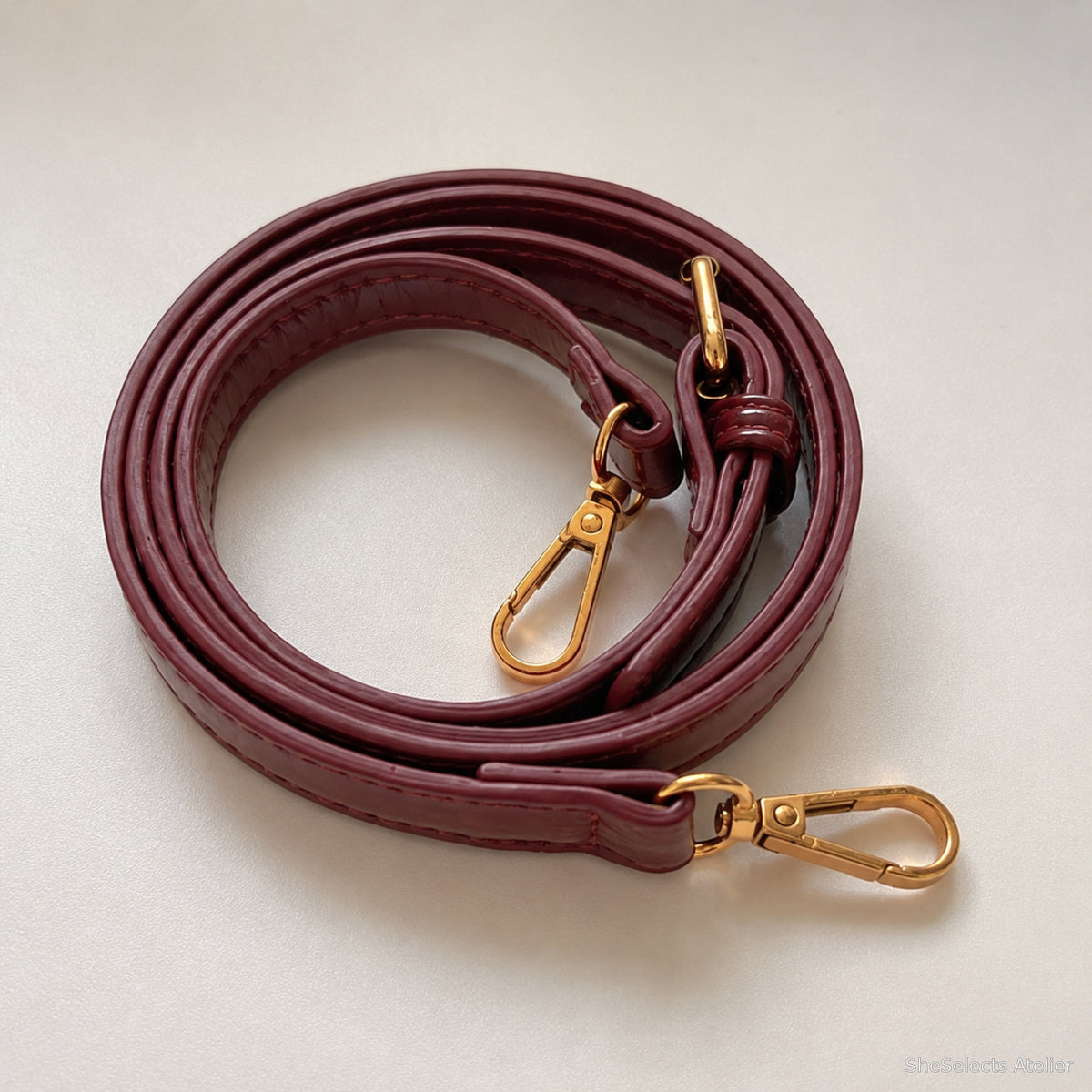 Detachable burgundy long strap with gold tone clasps