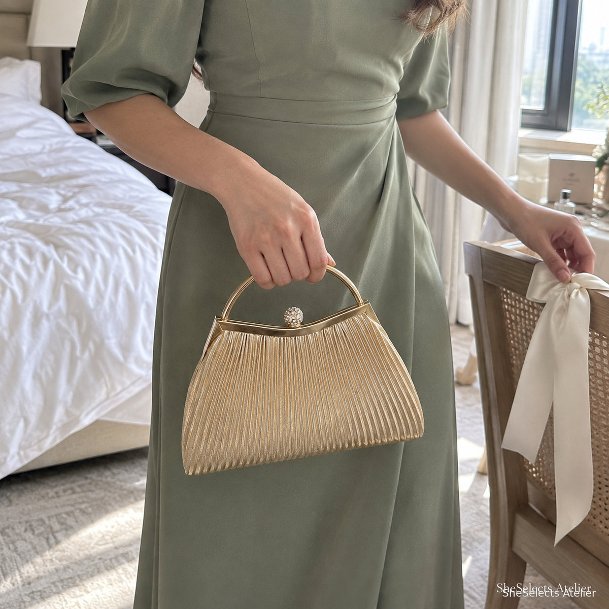 Bridesmaid holding the Celestine Gold pleated evening bag