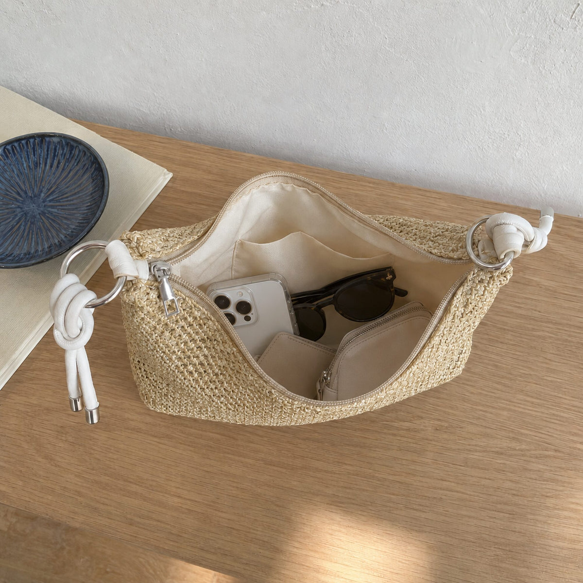 Cream knotted-handle woven straw hobo opened with phone, sunglasses, wallet and cosmetic pouch