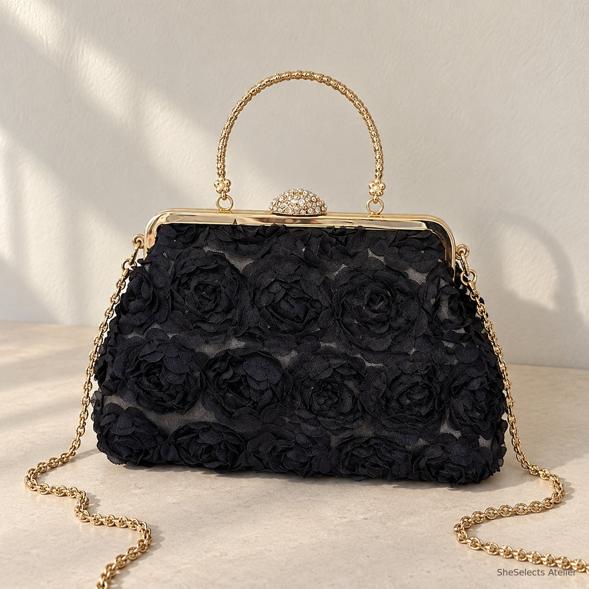 Black floral rosette handbag with gold handle and chain, front view