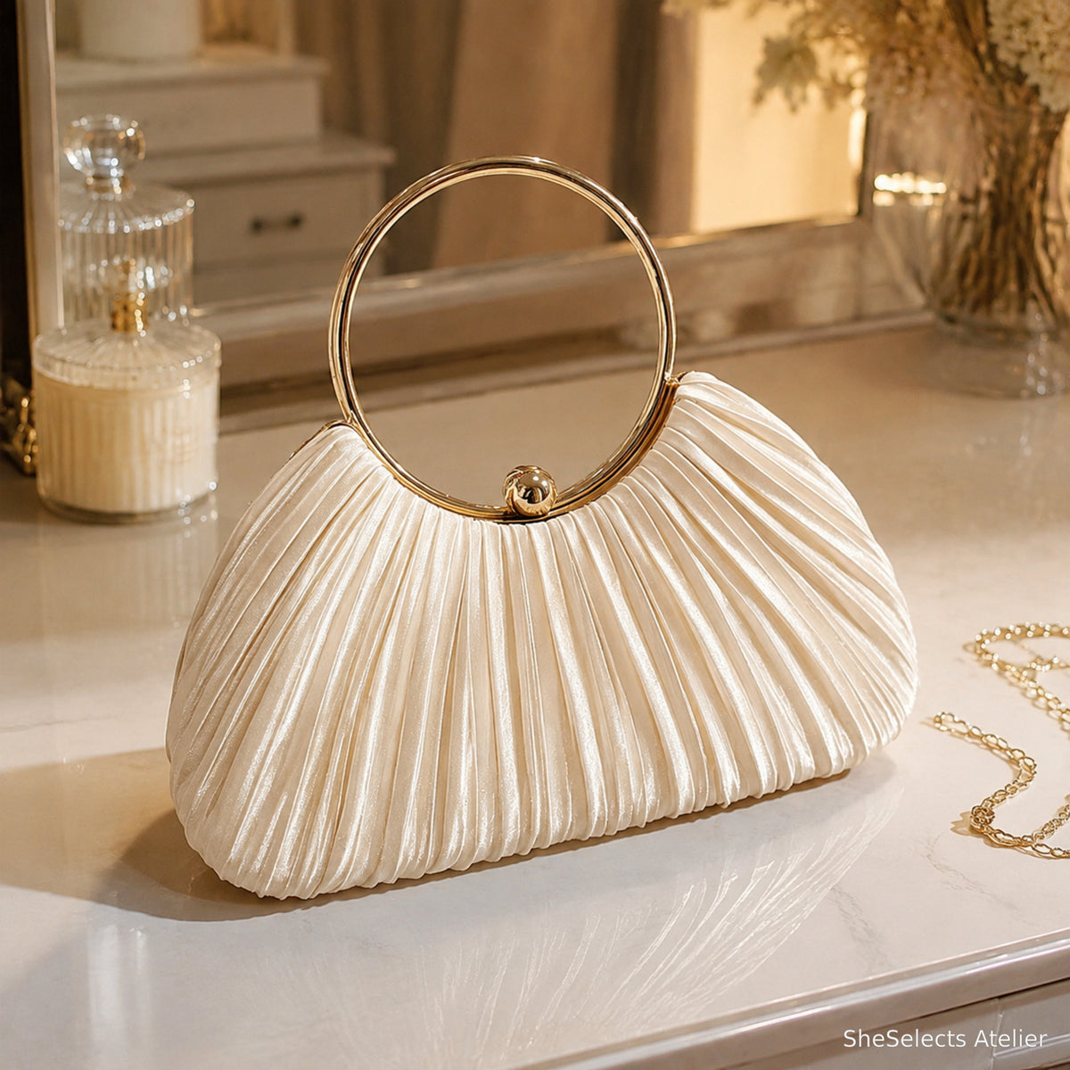 Champagne pleated satin ring handle evening clutch on an elegant vanity