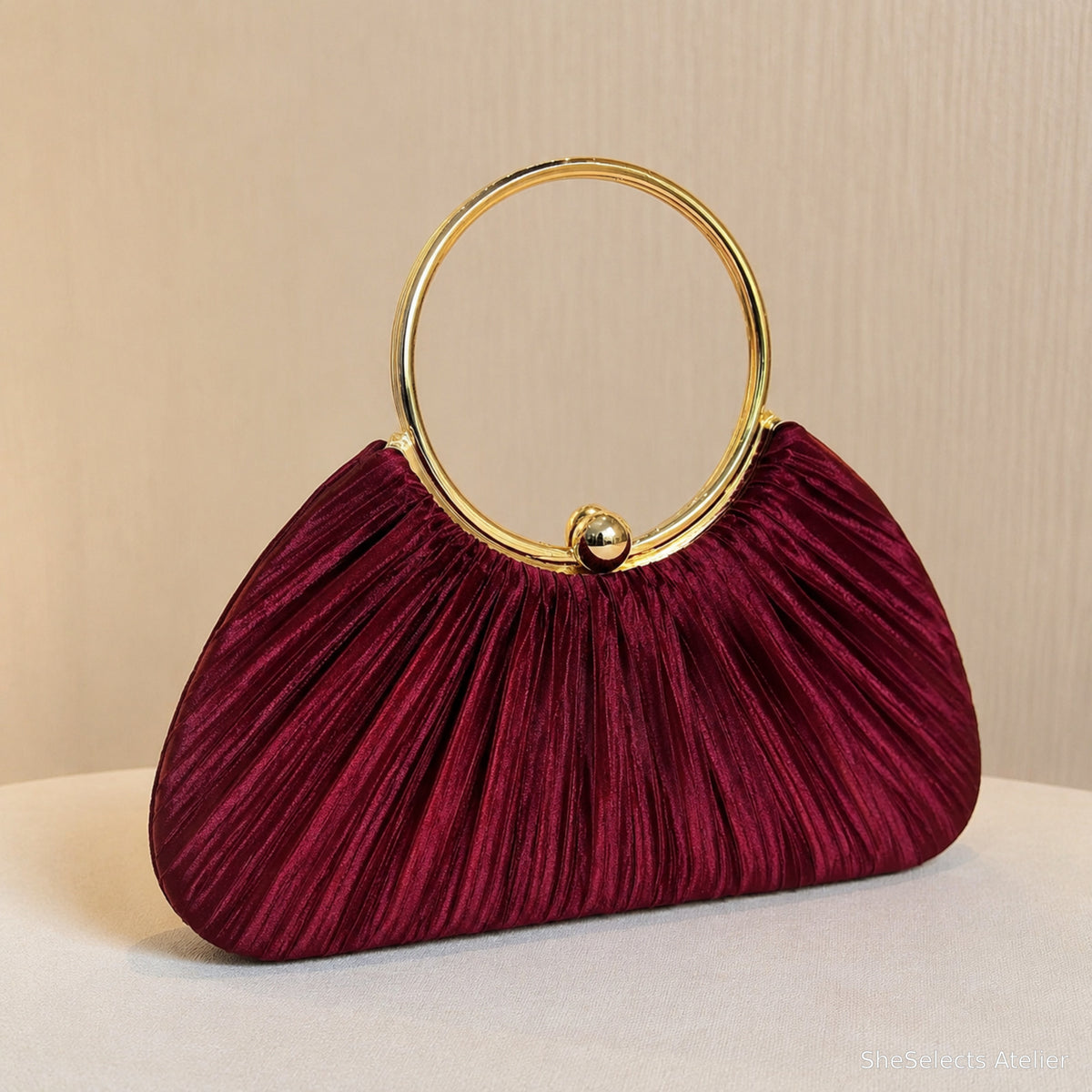 Burgundy pleated satin evening clutch with circular gold handle