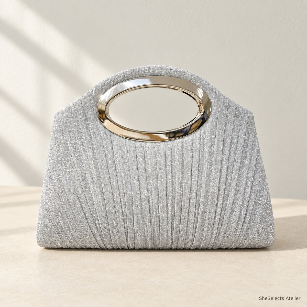 Silver pleated shell handbag with oval metal handle, front view