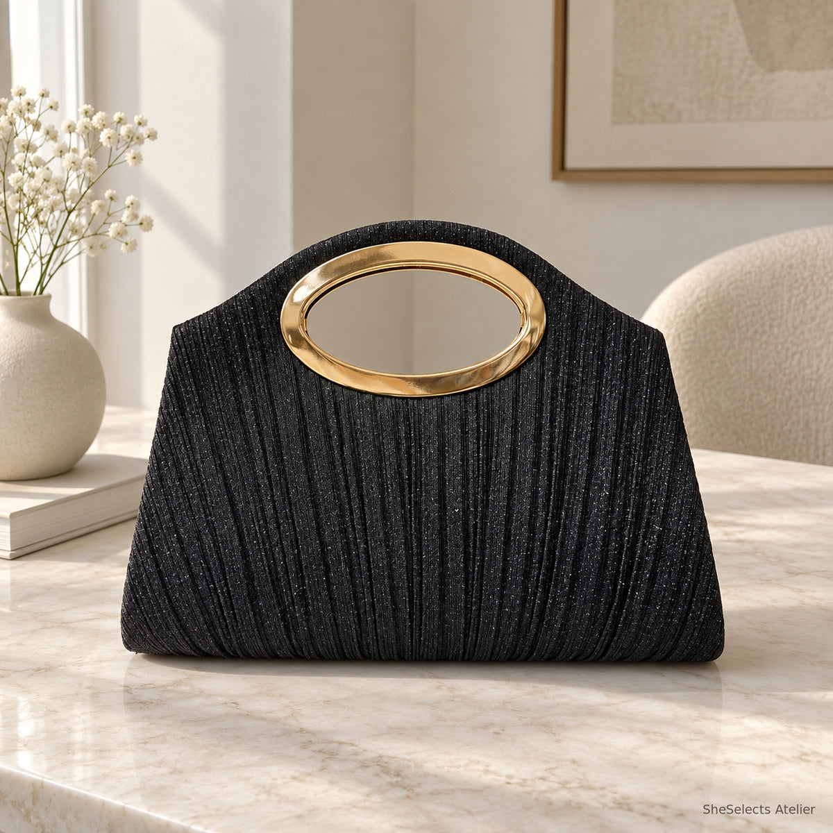 Black pleated shell handbag with oval metal handle, front view